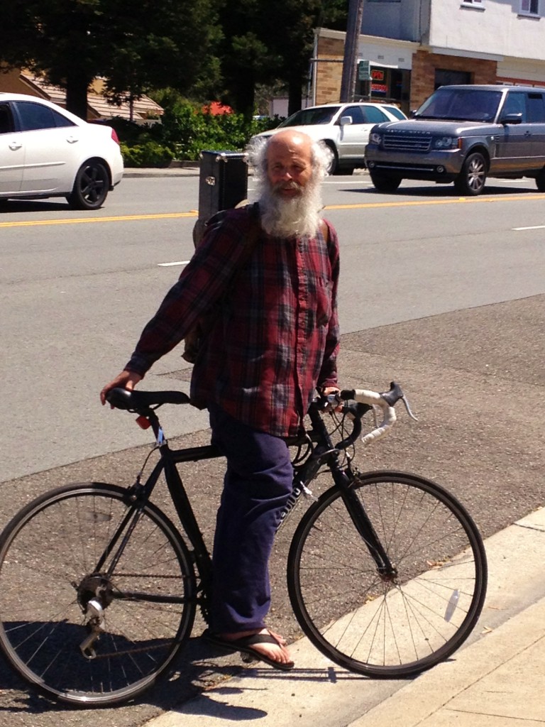 Greybeard cyclist off to saxaphone cyclist