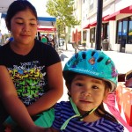 Greenfield girl helping little ones learn bike helmet fit 2012